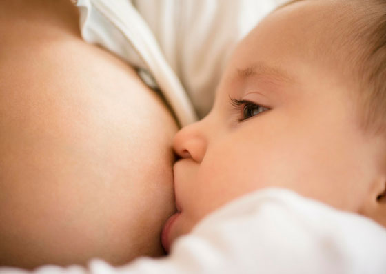 Bebê tomando leite no peito de sua mãe