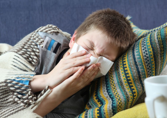 Criança deitada com muco no nariz, com sintomas de infecção